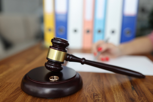 Wooden gavel for judge on stand is a wedding ring. Family divorce and division of property concept
